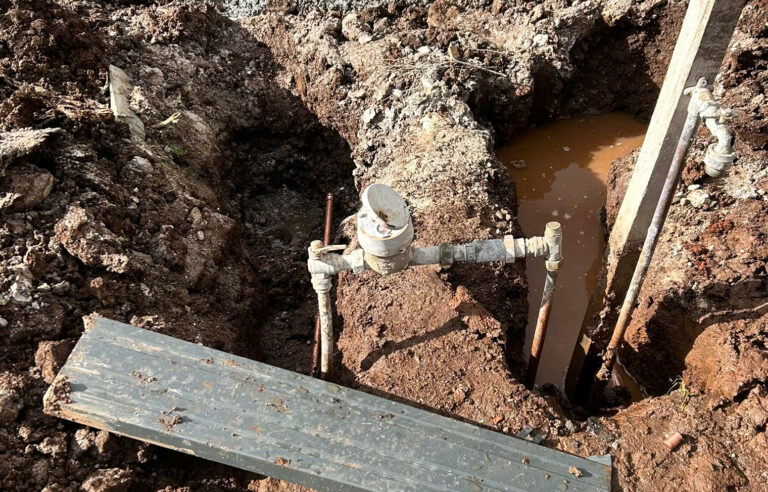Excavated area with water meter visible