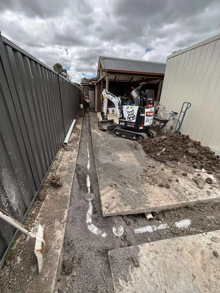 Services Excavator digging a trench for new drainage pipe installation